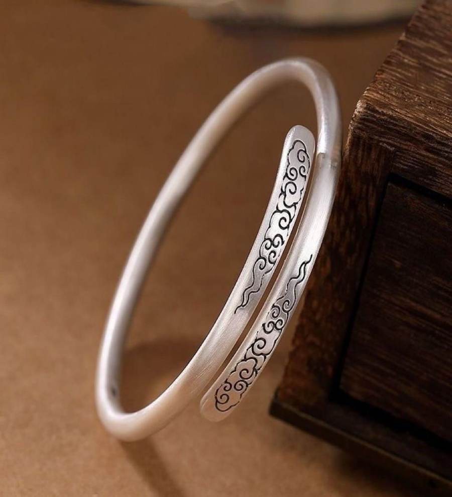 Chased silver bangle beside a wooden box