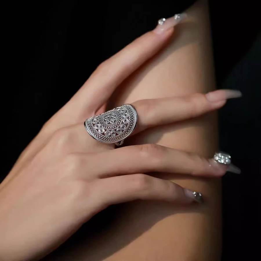Openwork silver ring worn on a hand