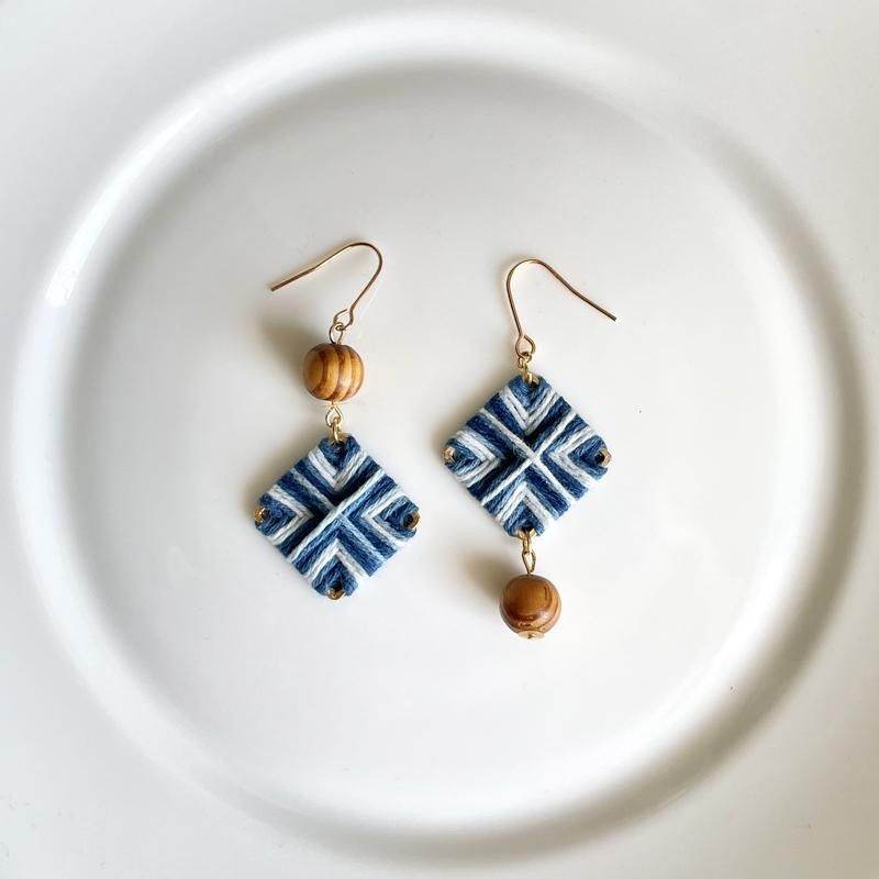 Earrings with a blue and white diamond pattern on a white plate