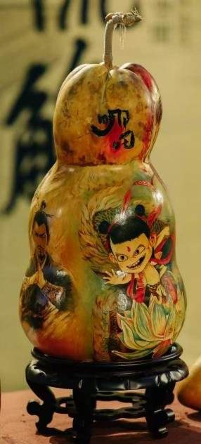 A double gourd on a stand painted with a smiling child figure