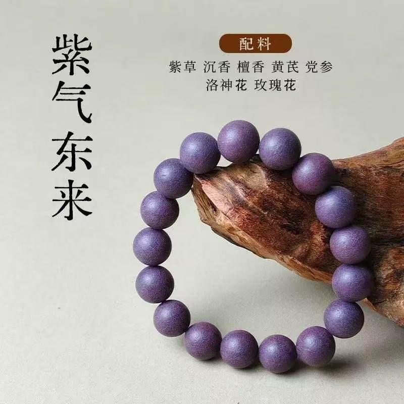 A bracelet of violet beads resting on a piece of root wood