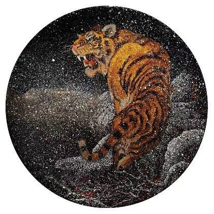 A round black plaque with a tiger in gold and silver flecks