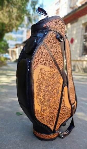A black golf bag with tan carved leather panels
