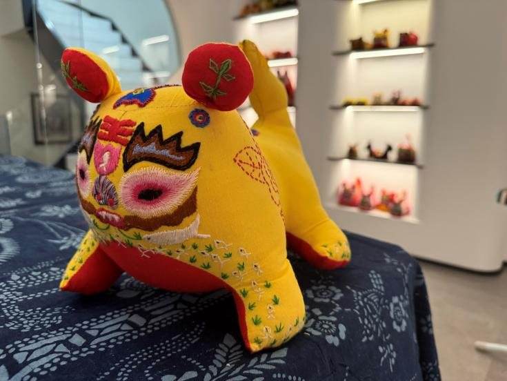 A tiger figure made of yellow cloth with an embroidered face and red ears